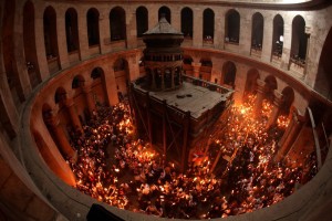 Worshippers gather in the rotunda of the Church of the Holy Sepulchre to light their candles from the 'Holy Fire' on the eve of Easter Sunday as the faithful flocked on April 03, 2010 around the church, built over the sites where Christians believe Christ was crucified and buried, in the narrow cobblestone alleys of annexed east Jerusalem's Old City. Tens of thousands of Christian pilgrims from Eastern churches converged on the Holy City to take part in the Easter "Holy Fire" vigil in which the "miracle" light from Jesus's tomb is shared by candles to the crowd. AFP PHOTO/GALI TIBBON (Photo credit should read GALI TIBBON/AFP/Getty Images)